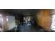 Damaged kitchen view shows water damage, wood paneling, debris, and discarded items throughout the property interior at 2702 W Stage Coach Trl, Shelby, NC 28150