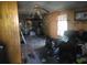 Damaged interior view shows water damage, wood paneling, debris, and discarded items throughout the property interior at 2702 W Stage Coach Trl, Shelby, NC 28150