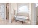 Bathroom featuring a soaking tub under an arched window and a separate glass shower at 3005 Dream Catcher Cir, Fort Mill, SC 29715