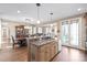 Open concept kitchen island with granite countertops, sink, stainless steel dishwasher, and adjacent dining area at 3005 Dream Catcher Cir, Fort Mill, SC 29715