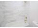 Bathroom features a tub with shower and attractive marble-look tile surround at 409 N Apple St, Gastonia, NC 28054