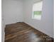 Sunlit bedroom featuring wood floors, a white door, and a bright window at 409 N Apple St, Gastonia, NC 28054