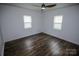 An airy bedroom with two windows, wood floors, and a ceiling fan at 409 N Apple St, Gastonia, NC 28054