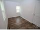 A compact bedroom featuring wood floors, a window, and a closet door at 409 N Apple St, Gastonia, NC 28054