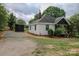 Wide exterior view of the house showing the driveway, storage shed, porch and side yard at 409 N Apple St, Gastonia, NC 28054