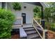 View of the house's covered front porch with new wooden railing and hanging plants at 409 N Apple St, Gastonia, NC 28054