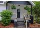 Inviting front porch with black accents and wooden railings, adorned with hanging ferns for curb appeal at 409 N Apple St, Gastonia, NC 28054
