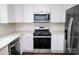 Well-lit kitchen showcasing stainless steel appliances, subway tile backsplash and white cabinetry at 409 N Apple St, Gastonia, NC 28054