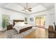 Spacious main bedroom with tray ceiling, ceiling fan, hardwood floors, and sliding glass doors to the patio at 426 Saint Michaels Way, Fort Mill, SC 29708