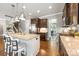 Well-lit kitchen featuring an island with granite countertops, stainless steel appliances, and dark wood cabinetry at 487 Hawks Creek Pkwy, Fort Mill, SC 29708