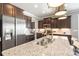 Close up of a kitchen island featuring stainless steel appliances, granite countertops, and dark wood cabinetry at 487 Hawks Creek Pkwy, Fort Mill, SC 29708