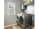 Laundry room with front load washer and dryer, utility sink, and overhead cabinet at 487 Hawks Creek Pkwy, Fort Mill, SC 29708