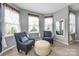 Cozy bedroom sitting area bathed in sunlight with two chairs and an ottoman at 487 Hawks Creek Pkwy, Fort Mill, SC 29708