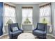 Cozy bedroom sitting area bathed in sunlight with two chairs and an ottoman at 487 Hawks Creek Pkwy, Fort Mill, SC 29708