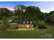 Nighttime view of a house with a well-manicured front lawn and mature trees at 4896 Pageland Hwy, Lancaster, SC 29720