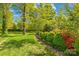 Side yard with mature trees and vibrant landscaping, offering a serene outdoor space at 4896 Pageland Hwy, Lancaster, SC 29720
