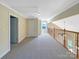 Open hallway with neutral walls and carpet, featuring a window and railing overlooking a lower level at 5104 Shannamara Dr, Matthews, NC 28104