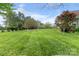 Spacious backyard with lush green grass, mature trees, and manicured landscaping at 557 Luther Dr, Iron Station, NC 28080