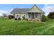 Charming home featuring a spacious backyard, screened porch, and well-maintained landscaping at 557 Luther Dr, Iron Station, NC 28080