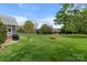 Expansive backyard with a gardening box and a glimpse of the home's exterior at 557 Luther Dr, Iron Station, NC 28080