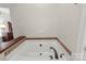 Relaxing bathroom features a large soaking tub with designer tile accents and wood trim at 557 Luther Dr, Iron Station, NC 28080