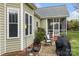 Charming home exterior showcasing a patio, sunroom, and verdant landscaping at 557 Luther Dr, Iron Station, NC 28080