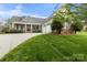 Inviting two-story home boasts a charming porch, two-car garage, and well-manicured lawn at 557 Luther Dr, Iron Station, NC 28080