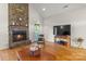 Cozy living room features stone fireplace, hardwood floors, and lots of natural light at 557 Luther Dr, Iron Station, NC 28080