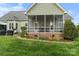 Charming screened porch and brick foundation overlooking a landscaped yard, ideal for relaxation and outdoor dining at 557 Luther Dr, Iron Station, NC 28080