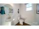 A cozy powder room features an updated vanity with a modern sink, toilet, and wood-look flooring at 7035 Butternut Oak Ter, Huntersville, NC 28078