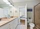 Bathroom featuring double sinks, white cabinets, and a view into the Primary bedroom at 7208 Ashton Gate Dr, Charlotte, NC 28270