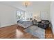 Bright bedroom featuring hardwood floors, a cozy chair, and a decorative ceiling light at 7208 Ashton Gate Dr, Charlotte, NC 28270