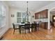 Bright dining room with a chandelier, hardwood floors, and large windows with custom cabinetry at 7208 Ashton Gate Dr, Charlotte, NC 28270