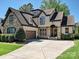 Charming two-story home featuring a stone and stucco facade, well-manicured landscaping, and a spacious driveway at 7208 Ashton Gate Dr, Charlotte, NC 28270