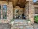 Inviting front porch with stone pillars, elegant stonework, and a beautifully decorated entryway at 7208 Ashton Gate Dr, Charlotte, NC 28270