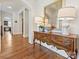 Elegant hallway featuring hardwood floors, neutral walls, decorative mirror, and stylish lamps at 7208 Ashton Gate Dr, Charlotte, NC 28270