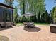 Stamped concrete patio has large dining set with shade umbrella and lush landscaping at 7208 Ashton Gate Dr, Charlotte, NC 28270