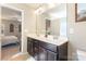 Bathroom with double sink vanity, a large mirror, neutral countertops and an open view of bedroom at 78090 Rillstone Dr, Lancaster, SC 29720
