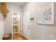 Hallway with Flower Market art print, a wooden shelf with hooks, and a decorative bowl near a doorway to the bathroom at 78090 Rillstone Dr, Lancaster, SC 29720