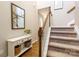 Hallway with staircase, wooden floors, a white console table, a mirror, and a view of the second-floor hallway at 78090 Rillstone Dr, Lancaster, SC 29720