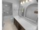 Modern bathroom with a large vanity, sleek mirrors, and a marble tiled shower and tub at 8000 Briardale Dr, Charlotte, NC 28212