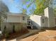 View of the home with light grey siding and stone foundation, accented by lush landscaping at 8000 Briardale Dr, Charlotte, NC 28212