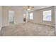 Spacious main bedroom featuring neutral carpet, two windows, and entrances to the bathroom and closet at 835 Holdcroft Ln, Rock Hill, SC 29730