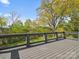 Spacious back deck area with gray wood flooring and stunning views of the surrounding trees at 913 Van Every St, Charlotte, NC 28205