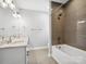 Well-lit bathroom with double vanity, modern fixtures, and tiled shower and tub at 913 Van Every St, Charlotte, NC 28205