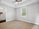 Bright bedroom featuring a ceiling fan, a tray ceiling, and an ensuite bathroom with a tiled shower at 913 Van Every St, Charlotte, NC 28205