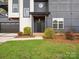 Contemporary home entrance featuring a black front door, manicured landscaping, and modern architectural design at 913 Van Every St, Charlotte, NC 28205