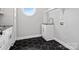 Chic laundry room featuring black and white tile flooring, cabinetry, and a round window for natural light at 913 Van Every St, Charlotte, NC 28205
