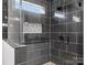 Sleek bathroom shower with black tile, glass enclosure, and built-in niche for storage at 913 Van Every St, Charlotte, NC 28205