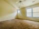 Spacious bedroom featuring a ceiling fan, neutral paint, carpet flooring, and natural light at 9615 Littleleaf Dr, Charlotte, NC 28215